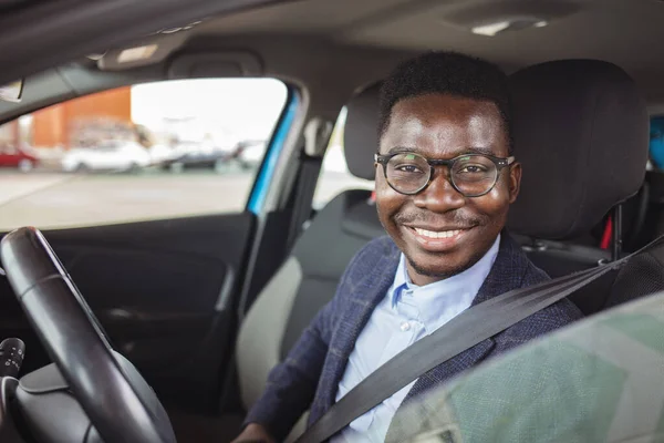 Businessman in his car fastening the seatbelt, safe driving concept. Car safety. Business man fastening seat belt in auto, driving to work, copy space. Man wearing seat belt in car before driving - safety rules