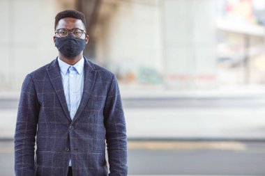  Koruyucu yüz maskesi takan ve gülümseyen yakışıklı Afro-Amerikan bir adamın portresi. Kavram, güvenlik, koruma, virüs, salgın, korona virüsü, grip, mikroplar, sorumluluk, yeni çağ.