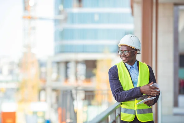 Construction Worker Planning Contractor Developer Concept. Portrait of African American Engineer at a construction work site. Successful male architect at a building site