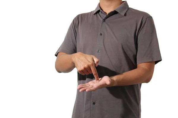 Sıradan kısa kollu tişörtlü bir adam parmağıyla avucunun içini gösteriyor.