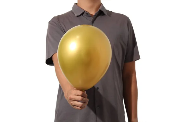 Beyaz arka planda izole edilmiş altın balon tutan sıradan kısa kollu bir adam.