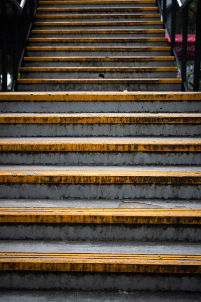 Portre oranında sarı çizgili yaya köprüsü merdivenleri.