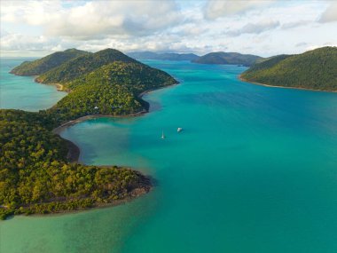 Queenslands kıyı şeridinin, el değmemiş plajların, turkuaz okyanus sularının ve tropikal adaların doğal güzelliklerini gösteren yüksek çözünürlüklü hava fotoğraflarının bir derlemesi. Profesyonel insansız hava aracı ekipmanlarıyla çekilen bu görüntüler canlı manzaraları gösteriyor.