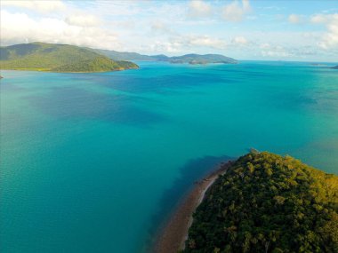 Queenslands kıyı şeridinin, el değmemiş plajların, turkuaz okyanus sularının ve tropikal adaların doğal güzelliklerini gösteren yüksek çözünürlüklü hava fotoğraflarının bir derlemesi. Profesyonel insansız hava aracı ekipmanlarıyla çekilen bu görüntüler canlı manzarayı gösteriyor..