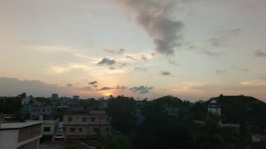 Şiddetli, karanlık bulutlarla dolu dramatik bir gökyüzü ağaçların karanlık siluetleri üzerinde belirir, karamsar ve atmosferik bir sahne yaratarak yaklaşan bir fırtınayı ya da hava değişimini gösterir..