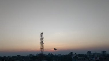 Şiddetli, karanlık bulutlarla dolu dramatik bir gökyüzü ağaçların karanlık siluetleri üzerinde belirir, karamsar ve atmosferik bir sahne yaratarak yaklaşan bir fırtınayı ya da hava değişimini gösterir..