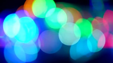 Siyah arka plandaki parlak ampullerin soyut bulanıklığı.