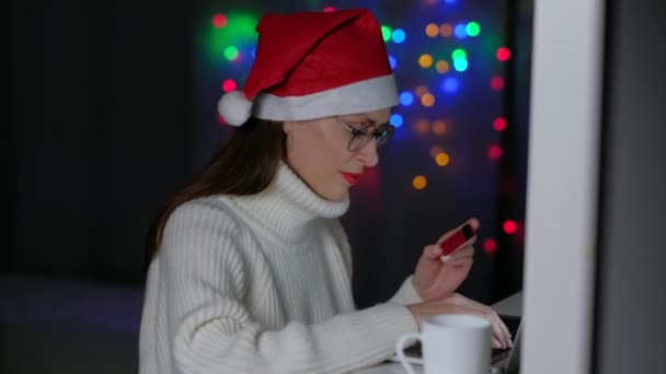 Femme détenant une carte de crédit et utilisant un ordinateur portable à la maison la nuit. — Video