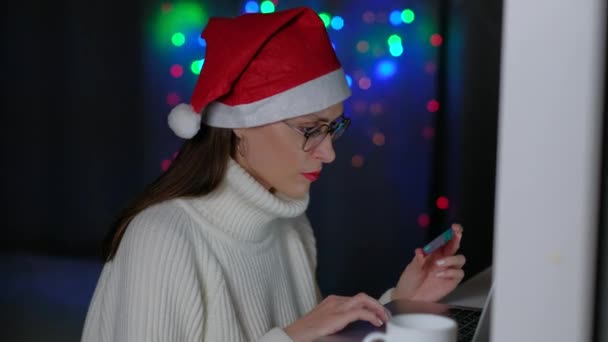 Žena držící kreditní kartu a pomocí notebooku doma v noci. — Stock video