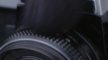 Siyah fırçalı eski fotoğraf makinesinin tozundan temizlik yapıyor.. 