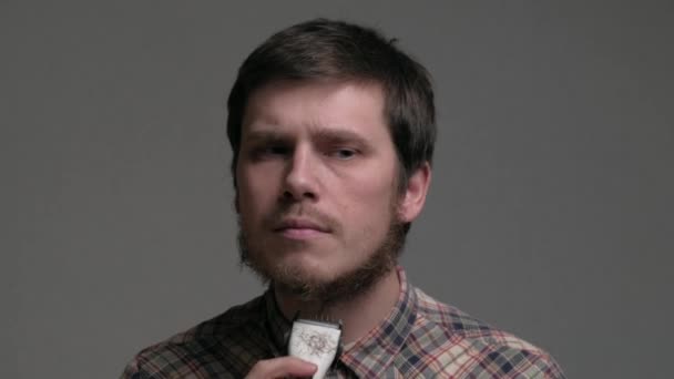 Muž začíná holit vousy strojem na holení. — Stock video