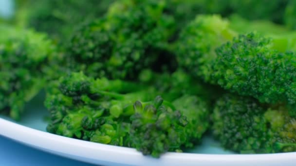 Brócoli verde fresco en plato sobre fondo azul. — Vídeos de Stock