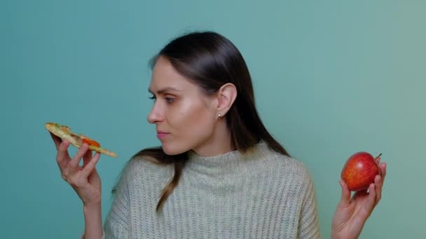 Tatlı bir kadın bir dilim pizza yerine kırmızı elmayı seçiyor.. — Stok video