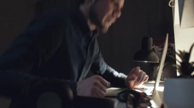 Adam geceleri dizüstü bilgisayarda çalışıyor..