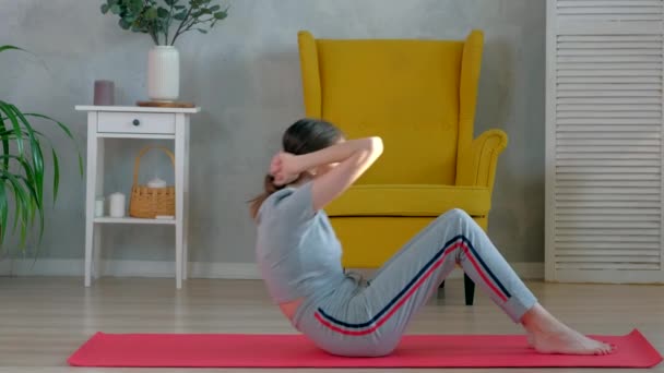 Brunetka Kobieta robi crunches ćwiczenia rano w domu. — Wideo stockowe