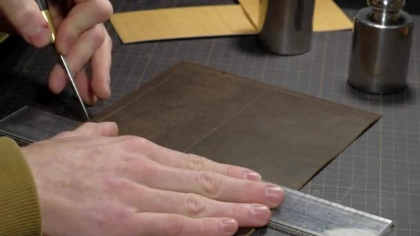 Mains d'une personne qui travaille le cuir sur le lieu de travail. — Video