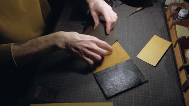 Mãos de uma pessoa que trabalha com couro no local de trabalho. — Vídeo de Stock