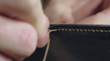 Bronzlaştırıcı deri iş parçalarını dikiyor. El yapımı küçük bir el yapımı..