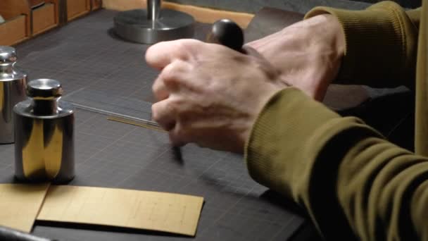 Ruce člověka, který pracuje s kůží na pracovišti. — Stock video