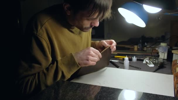 Osoba krejčí, která pracuje s kůží na pracovišti. — Stock video