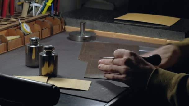 Mãos de uma pessoa que trabalha com couro no local de trabalho. — Vídeo de Stock