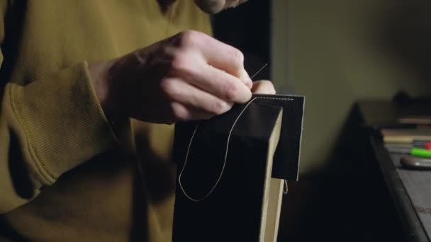 Der Gerber näht die Lederwerkstücke. Handgefertigt in einer kleinen Manufaktur in Großaufnahme. — Stockvideo