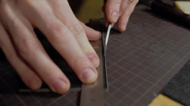 Handicraftsman cutting edges of new leather wallet — Stock Video