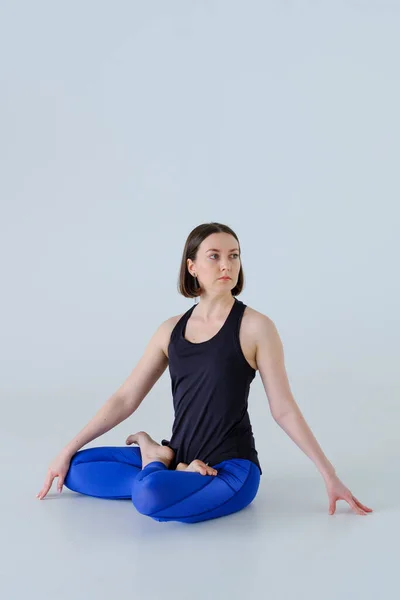 Mujer joven en ropa deportiva practicando yoga. Imágenes de stock libres de derechos