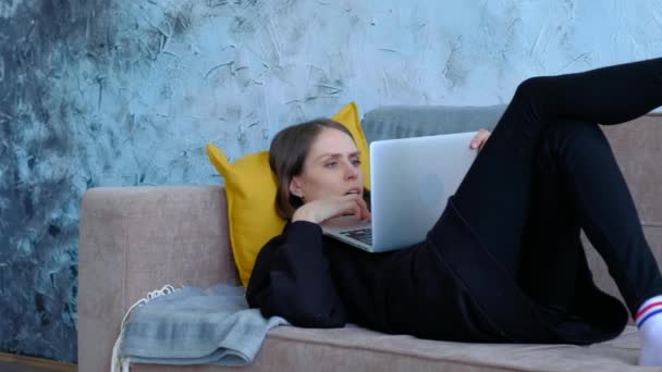 Жінка використовує блокнот, що розслабляється вдома . — стокове відео
