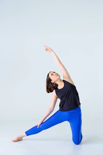 Adatta donna in abbigliamento sportivo praticare yoga gate posa a casa. — Foto Stock