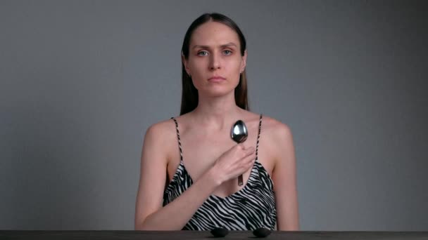 Magnetic woman with spoons attached to his skin. — Stock Video