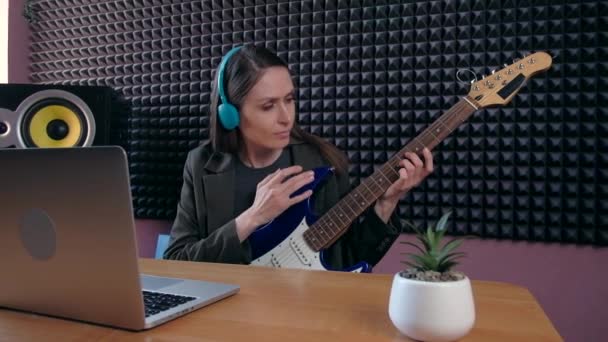 Aprendizaje femenino tocar la guitarra en casa usando lecciones en línea. Hobby educación musical remota electro guitarra. — Vídeos de Stock