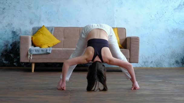 マスターヨガの女性は家でポーズをしています, Prasarita Padottanasana. — ストック動画