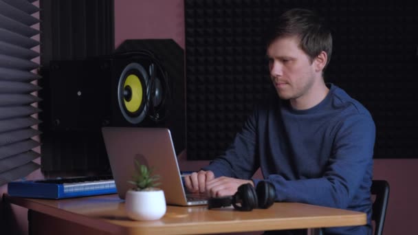 Diseñador de sonido trabajando en notebook en estudio de música. — Vídeo de stock