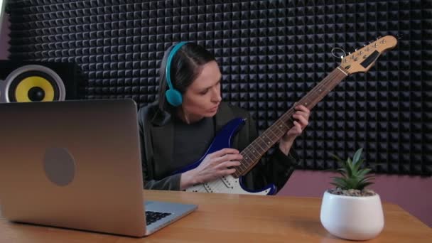 Aprendizaje femenino tocar la guitarra en casa usando lecciones en línea. Hobby educación musical remota electro guitarra. — Vídeos de Stock