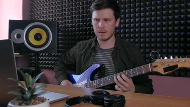 Mužské učení hrát na kytaru doma pomocí online lekcí. Hobby vzdálená hudební výchova elektro kytara. — Stock video