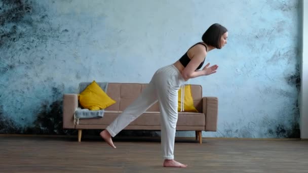 Vacker kvinna som gör yoga hemma fönster, Virabhadrasana III, Warrior Pose III — Stockvideo