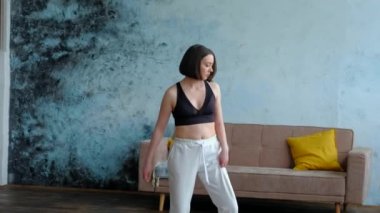Oturma odasında yoga pozu vermiş bir kadın..