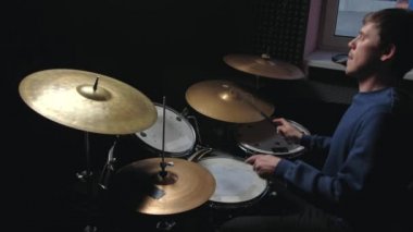 Adam davul çalmak için oturur.