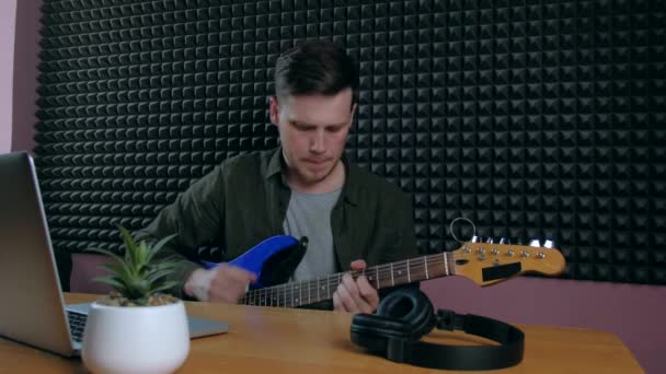 Man leren gitaar spelen thuis met behulp van online lessen. Hobby op afstand muzikaal onderwijs electro gitaar. — Stockvideo