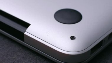 Usta bozuk dizüstü bilgisayarın manyetik tornavidayla küçük vidaları vidalıyor.