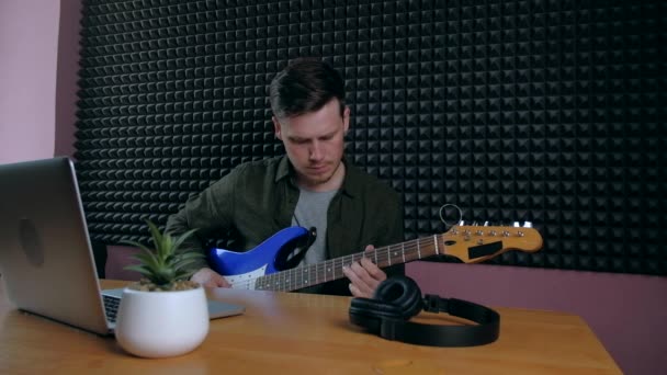 Man leren gitaar spelen thuis met behulp van online lessen. Hobby op afstand muzikaal onderwijs electro gitaar. — Stockvideo