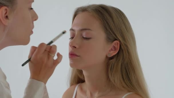 Młody makijaż artysta robi makijaż do Pretty Model — Wideo stockowe
