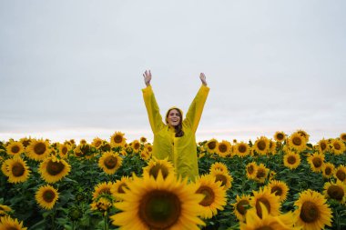 Neşeli bir gülümseme kadın ayçiçeği tarlasında kalır.