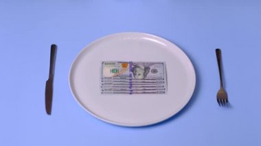 Eller tabaktaki bir dolarlık banknotu yemeye çalışır, çatal bıçak, 4K video kullanarak.