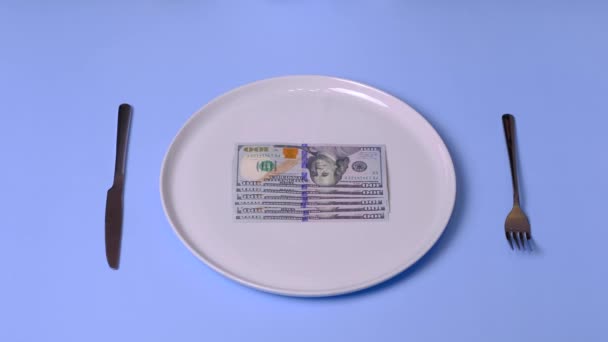 Χέρια προσπαθούν να φάνε ένα δολάριο νομοσχέδιο στο πιάτο, χρησιμοποιώντας μαχαιροπίρουνα, 4k βίντεο — Αρχείο Βίντεο