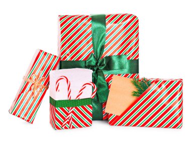 Kırmızı ve yeşil çizgili kağıda sarılı dört Noel hediyesi, içinde yeşil kurdele, şeker kamışları ve boş kahverengi bir hediye etiketi var. Yüksek kalite fotoğraf