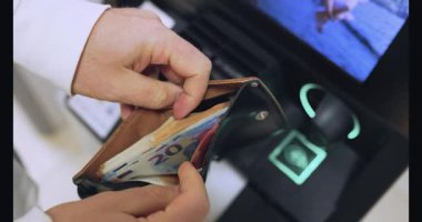 Cüzdandan avro banknotlarını alıp ATM 'nin yanında saymaya başla. Yüksek kalite 4k görüntü