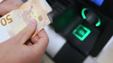 Bankamatik yeşil kart okuyucusunun yanındaki 50 Euro 'luk nakit paraları sayarak el sıkışın. Yüksek kalite 4k görüntü