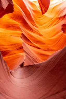 Oyulmuş, dalgalı kumtaşı duvarların slot kanyonu içinde aşırı yakın plan, zengin turuncu rengi ve pürüzsüz dokuyu vurguluyor.